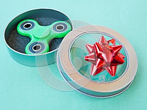 Popular colourful fidget spinner toy in a gift box on a colored background