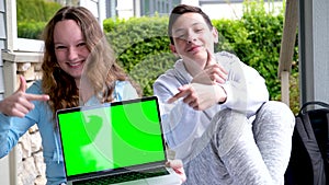 Popular cool photo of teens holding laptop green edge chroma key they showing fingers ad online learning teenage life