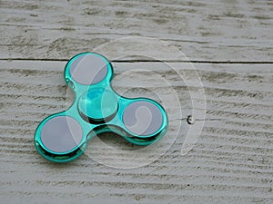 Popular fidget spinner toy on white wood background