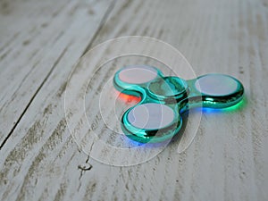 Popular fidget spinner toy on white wood background