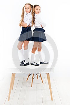 Popular girls in classroom. School friendship. Schoolgirls tidy appearance school uniform. Childhood happiness. School