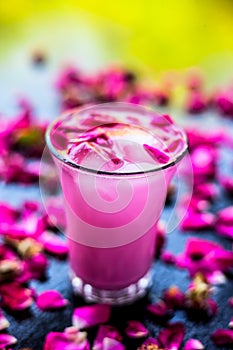 Popular Indian & Asian Summer drink on wooden surface i.e. Gulab falooda or gulab ka sherbat with some rose petals