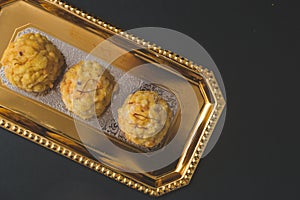 Popular Indian sweet dish known as Boondi laddu served in golden platter. photo