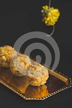 Popular Indian sweet dish known as Boondi laddu served in golden platter. photo