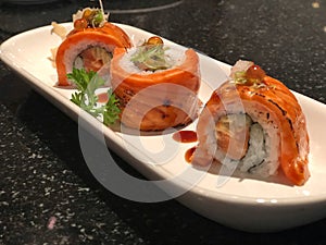 Popular Japanese food.Grilled Salmon Sushi Rolls in white plate