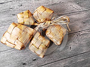 Popular Malay traditional Ramadan food Ketupat rice or Ketupat Palas with selective focus on wooden background.