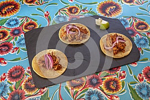 popular Mexican cochinita pibil tacos on corn tortillas in a restaurant