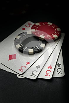 A popular poker game with a winning combination of four of a kind or quads. Chips and cards on the black table