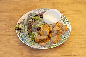 Popular Spanish recipe for marinated dogfish battered and fried in olive oil with oak lettuce and mayonnaise