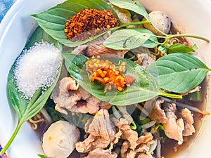 Popular street food in Thailand, Spicy pork noodle that consisted of pork ball, pork meat, basil or thyme, bean sprouts, morning