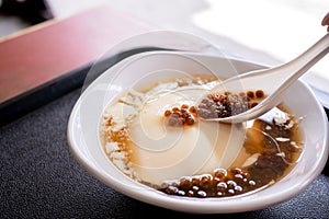 Popular Taiwan gourmet - Dessert of tapioca pearl ball bubble mixed bean curd tofu pudding douhua, dou hua in white bowl,