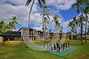 A popular two storey island resort full of coconut trees in tropical Nadi, Fiji with large size chess board game on the grass