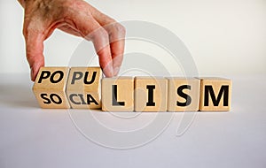 Populism or socialism. Hand turns cubes and changes word `globalism` to `populism`. Beautiful white background, copy space.