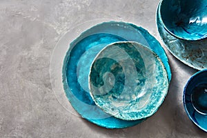 Porcelain blue bowls and plates on a gray table . Colorful ceramic vintage handmade dishes. Flat lay