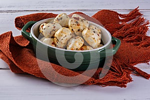 porcelain container with balls of seasoned buffalo mozzarella