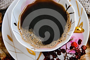 Porcelain cup of black coffee, close up, top view