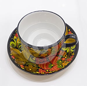 Porcelain cup and saucer from a tea set covered in Russian style in Khokhloma