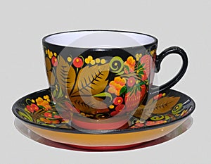 Porcelain cup and saucer from a tea set covered in Russian style in Khokhloma