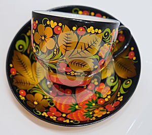 Porcelain cup and saucer from a tea set covered in Russian style in Khokhloma