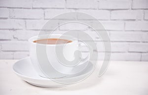 Porcelain cup of tea with milk on the white table