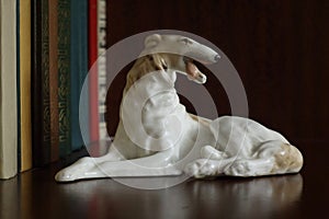 Porcelain figurine of a dog of breed Russian Greyhound on a bookshelf