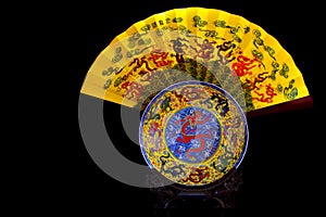 Porcelain plate and paper fan with dragon patterns on wooden stand