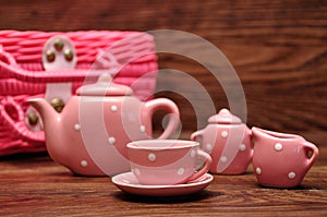 A porcelain spotted tea set with a pink basket