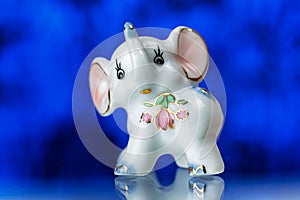Porcelain statuette, porcelain statuette of the elephant on a blue background