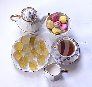 Porcelain tea set with milk, macaroni and marmalade, milk jug, tea cup, cup and saucer, gummy candy
