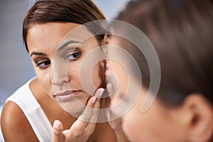 Pores, woman and skincare in mirror with face spot or pimple or acne on cheek. Female person, pointing and serious with