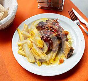Pork baked shank with vegetables and french fries served