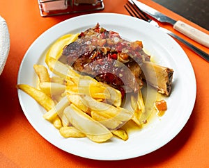 Pork baked shank with vegetables and french fries served