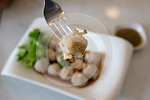 A pork ball on fork in Thai restaurant.