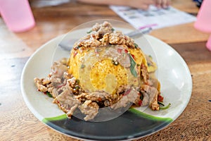 Pork Basil with Egg on table with soft light