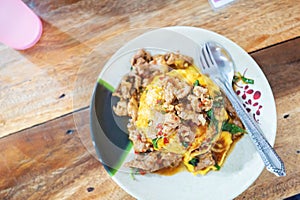 Pork Basil with Egg on table with soft light