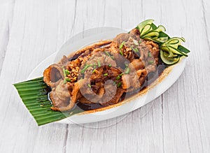 Pork Bistek Tagalog served in dish isolated on grey wooden background side view of fastfood photo
