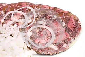 Pork brawn slices with onion on plate