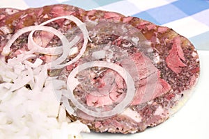 Pork brawn slices with onion on plate