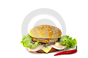 Pork burger with cheese, onion, tomato and lettuce on a wooden cutting board