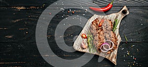 Pork Burger on chopping board. beef steak on a BBQ grill. Long banner format. top view