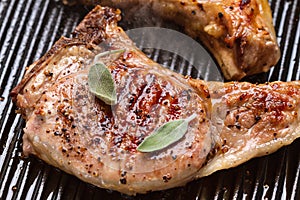 Pork chop in a frying pan grill closeup