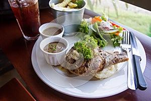 Pork chop served with mashed potatoes, salad and french fries.