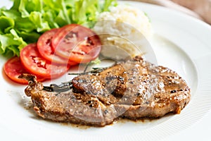 Pork chop steak with mash potato in white plate