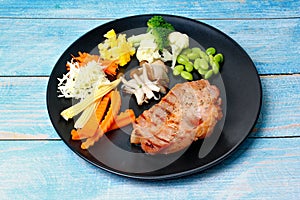 Pork Chop Steak served with mixed vegetable as stream carrot ,corn,green bean,lettuce and mushroom