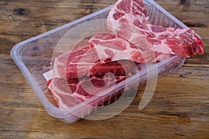 Pork chopped steak top view in plastic tray, home cooking concept, protein food ingredient, background with copy space