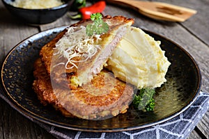 Pork cutlets coated in potato batter, studded with cheese and served with mashed potato