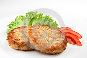 Pork cutlets with salad and slices of tomato isolated on white background