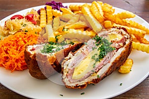 Pork Devolay. chop de volaille, chicken breast, chicken meat with cheese, French fries, salads photo
