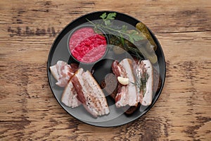 Pork fatback with rye bread and ingredients on wooden table, top view