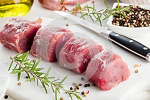 Pork fillet. Raw meat with spices on cutting board.
